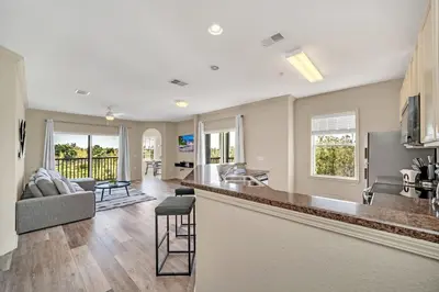 a kitchen and living room of a home with a bar at Upstay Pet Friendly Condo 6 Minutes from Disney in Orlando