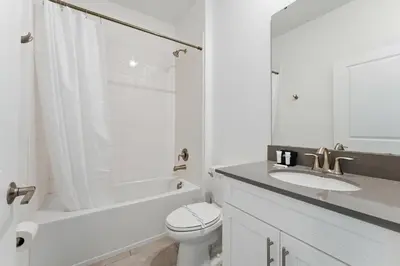 a white bathroom with a toilet and a sink at 4350 Storey Lake 17 guests near parks poolspa in Kissimmee