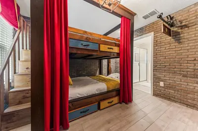 a bedroom with a bunk bed in a brick wall at New Storey Lake Dream Family Escape in Kissimmee