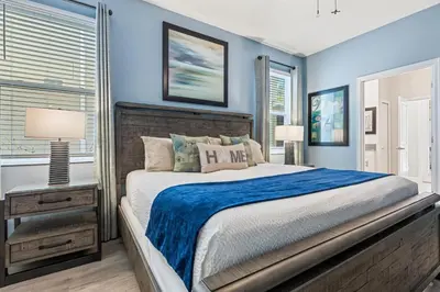 a bedroom with a large bed and blue walls at New Storey Lake Dream Family Escape in Kissimmee
