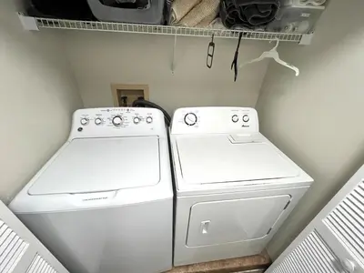 a laundry room with two white washers and a shelf at DisneyCondo 10 PP Mr Fredricksen House in Kissimmee