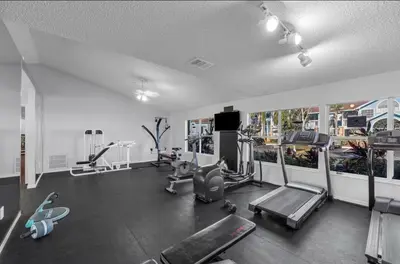 a gym with treadmills and machines in a room at DisneyCondo 10 PP Mr Fredricksen House in Kissimmee