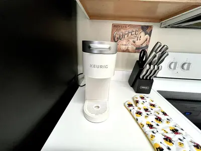 a kitchen counter with a keurig coffee maker and a remote control at DisneyCondo 10 PP Mr Fredricksen House in Kissimmee