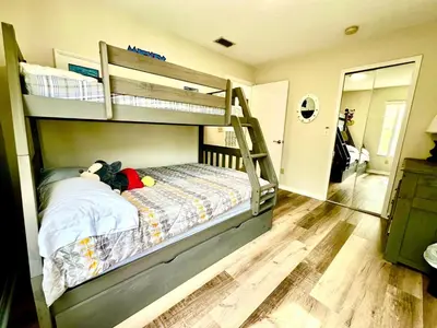 a bedroom with bunk beds with a teddy bear laying on a bed at DisneyCondo 10 PP Mr Fredricksen House in Kissimmee