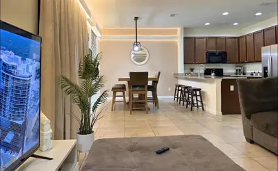 a living room and kitchen with a table and chairs at Family Home 20 min Disney 4BR Heated Pool BBQ in Kissimmee