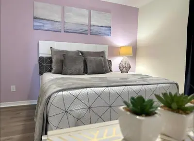 a bedroom with a bed and two potted plants at Family Home 20 min Disney 4BR Heated Pool BBQ in Kissimmee