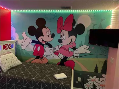 a bedroom with a mickey mouse mural on the wall at Family Home 20 min Disney 4BR Heated Pool BBQ in Kissimmee