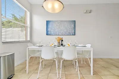 a white dining room with a white table and white chairs at Magic Home! GREAT Spot - 15Min Disney20 Universal in Kissimmee