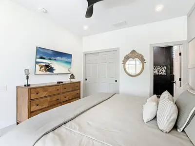 a white bedroom with a large bed and a mirror at 4BR Luxury Villa, Pool & GameRoom in Windsor Hills in Orlando