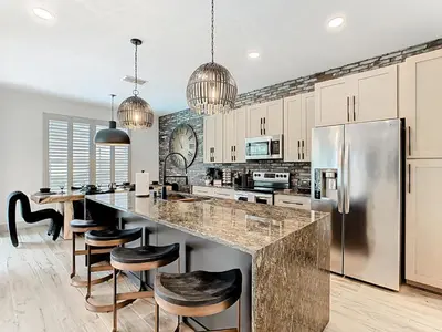 a kitchen with a large island with bar stools at 4BR Luxury Villa, Pool & GameRoom in Windsor Hills in Orlando