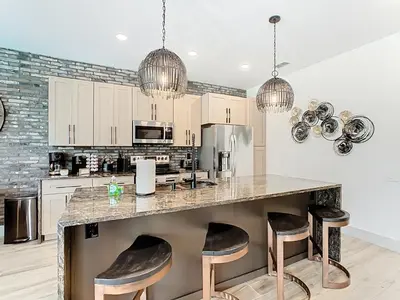 a kitchen with a large island with bar stools at 4BR Luxury Villa, Pool & GameRoom in Windsor Hills in Orlando