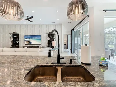 a kitchen with a sink in a living room at 4BR Luxury Villa, Pool & GameRoom in Windsor Hills in Orlando