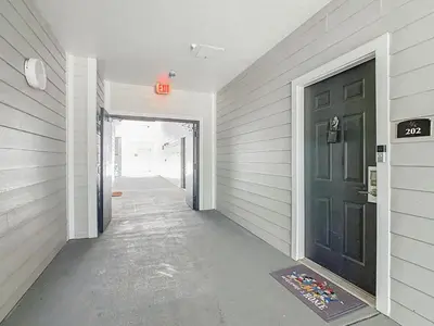 a hallway with a black door in a house at Themed 2BR Condo Near Disney + Resort Amenities in Kissimmee
