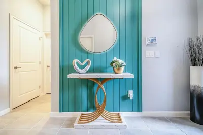 a mirror on a console table in a hallway at Mansão 8Q Disney c/ Cinema, Game Room, Piscina in Orlando