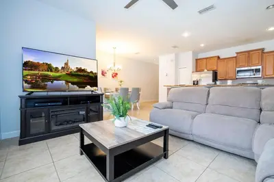 a living room with a couch and a flat screen tv at Paradise Palms - Spacious house and swimming pool in Kissimmee