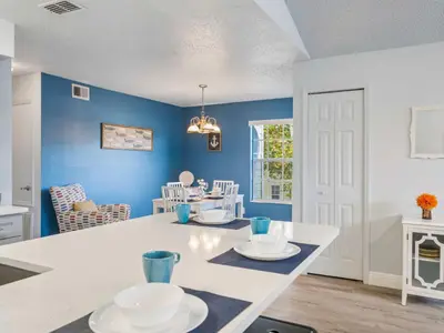 a kitchen with blue walls and a table with plates on it at 5005 Laguna Bay Cir 18 in Kissimmee