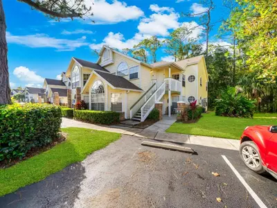 a house with a red car parked in a parking lot at 5005 Laguna Bay Cir 18 in Kissimmee