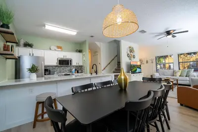 a kitchen and living room with a table and chairs at Cozy 4 BR close to Disney in Kissimmee