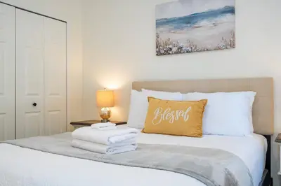 a bedroom with a white bed with a yellow pillow at Cozy 4 BR close to Disney in Kissimmee