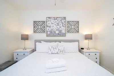 a bedroom with a white bed with two night stands at Cozy 4 BR close to Disney in Kissimmee