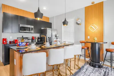 a kitchen with a bar with white chairs in it at 3 Bedroom 8 Miles from Disney Word in Kissimmee