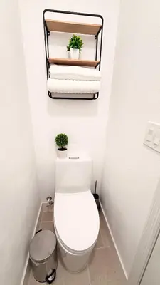 a bathroom with a toilet and towels on a shelf at Hermoso apartaestudio en Orlando in Orlando