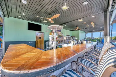 a bar with a long wooden table and chairs at 2BR Fireworks View with Pool & Spa 5 Minutes to Disney in Orlando