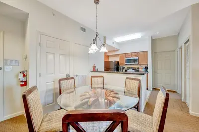 a dining room with a glass table and chairs at 2BR Fireworks View with Pool & Spa 5 Minutes to Disney in Orlando