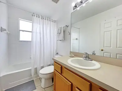 a white bathroom with a sink and a toilet at Endless Summer home in Kissimmee