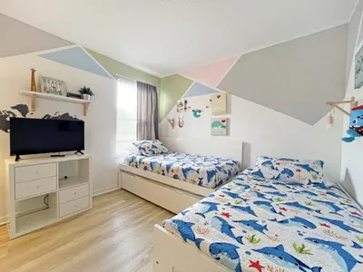a bedroom with two beds and a tv in it at Endless Summer home in Kissimmee