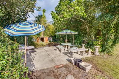 a patio with two umbrellas and a table and benches at 1 Mi to Historic Dtwn Sanford! Pet-Friendly Unit in Sanford