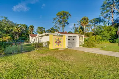 a house with a flower painted on the garage at 1 Mi to Historic Dtwn Sanford! Pet-Friendly Unit in Sanford