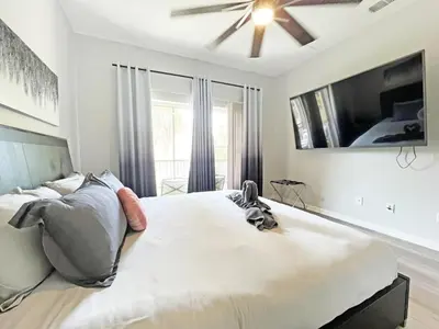 a bedroom with a large bed with a ceiling fan at Oakwater Lookout condo in Orlando