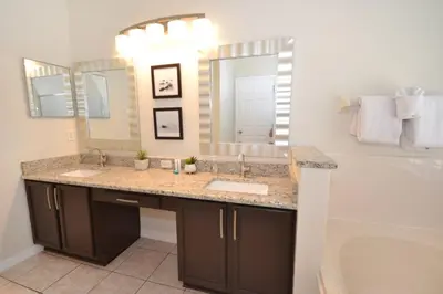 a bathroom with a sink and a large mirror at Villa Tropics villa in Orlando