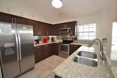 a kitchen with a stainless steel refrigerator and a sink at Villa Tropics villa in Orlando