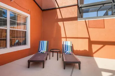 two benches sitting next to a building with a window at Paradise 4Bd w Private Pool & Waterpark 8951 in Kissimmee