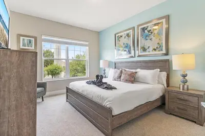 a bedroom with a large bed and two windows at Sunrise Shores townhouse in Orlando