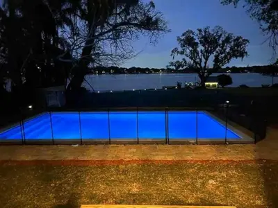 a swimming pool at night with blue illumination at Casa 5Q c/ Piscina e Vista Lago — 3min Universal in Orlando