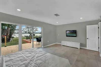 a bedroom with a bed and a sliding glass door at Casa 5Q c/ Piscina e Vista Lago — 3min Universal in Orlando