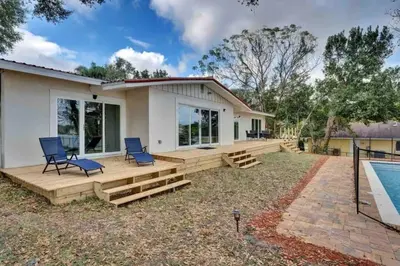 a house with a deck and a swimming pool at Casa 5Q c/ Piscina e Vista Lago — 3min Universal in Orlando