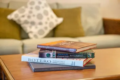 a stack of books sitting on a coffee table at Serene Gem, close to Disney- HEATEDsaltwaterPOOL in Kissimmee