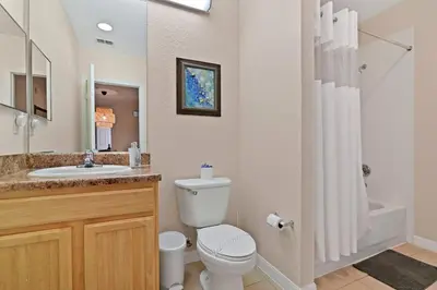 a bathroom with a toilet and a sink and a shower at Serene Gem, close to Disney- HEATEDsaltwaterPOOL in Kissimmee