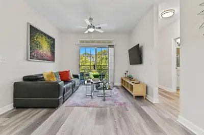 a living room with a couch and a tv at Stylish 3BR Condo Near Disney Pool, Gym & More! in Kissimmee
