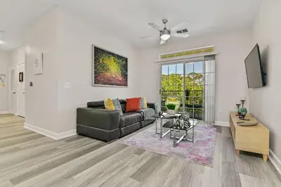 a living room with a couch and a table at Stylish 3BR Condo Near Disney Pool, Gym & More! in Kissimmee