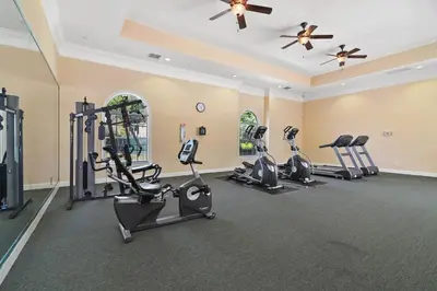 a fitness room with treadmills and cardio machines at Stylish 3BR Condo Near Disney Pool, Gym & More! in Kissimmee