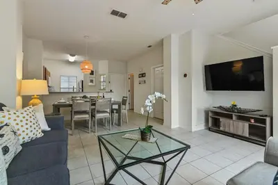 a living room with a blue couch and a tv at Adventure Awaits! Pool Home just 10 Min to Disney! in Kissimmee