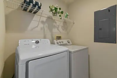 a laundry room with a washing machine and a shelf at Adventure Awaits! Pool Home just 10 Min to Disney! in Kissimmee