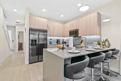 a kitchen with a large island with bar stools at Unplug in your private oasis-NEW corner Home Pool in Orlando