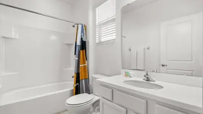 a white bathroom with a sink and a toilet at Upstay Bella Vida Retreat w Pool Cinema and Games in Kissimmee