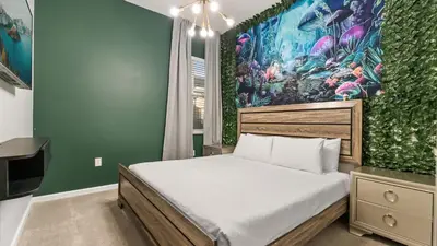 a bedroom with a large bed and a green wall at Upstay Bella Vida Retreat w Pool Cinema and Games in Kissimmee